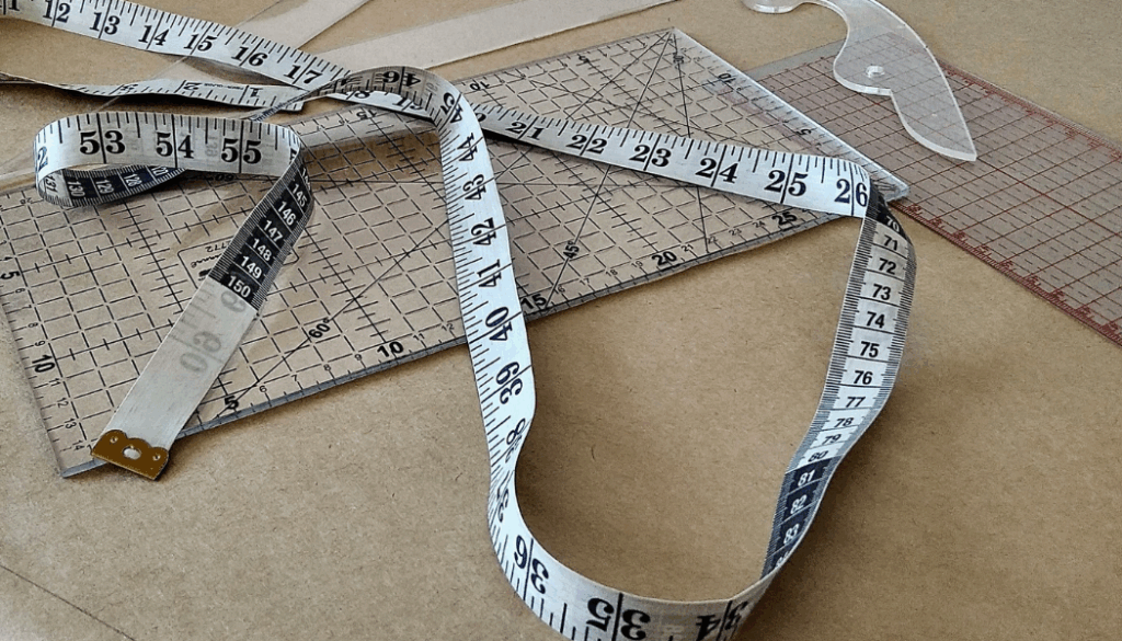 table avec metre ruban, règles et équaires